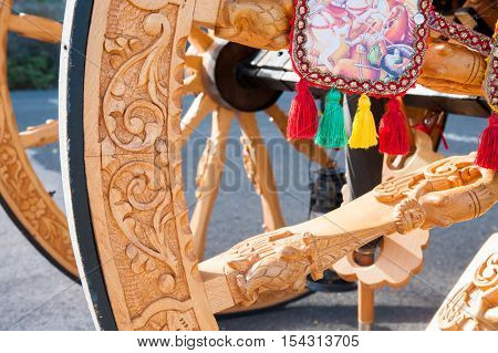 Closeup view of a wooden carved wheel of a typical sicilian cart during a folkloristic show