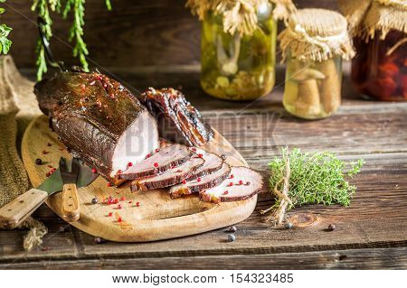 Smoked ham with juniper smoke on wooden table