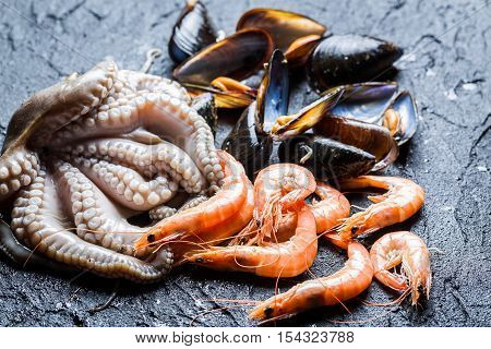 Three kinds of fresh seafood on black rock