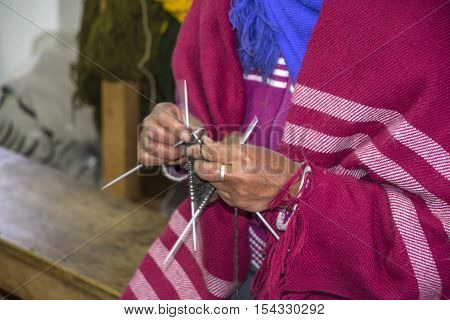 Close-up of a hands knitting. Lady in a sewing plant, outskirts of Guaranda, Bolivar province, Ecuador