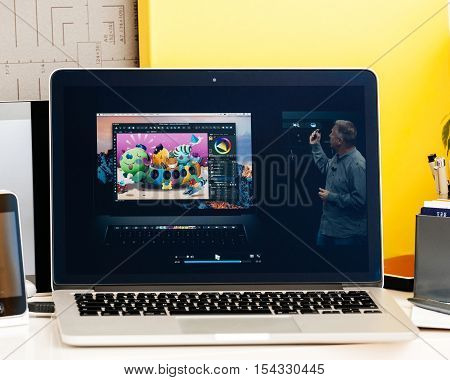 PARIS FRANCE - OCT 28 2016: Apple Computers website on new MacBook Pro Retina with OLED Touch bar in geek creative room showcasing Apple Keynote presentation of Philip Schiller inegration software