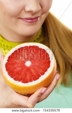 Dieting weight loss health care concept. Woman with yellow measuring tape on neck holds grapefruit isolated on white