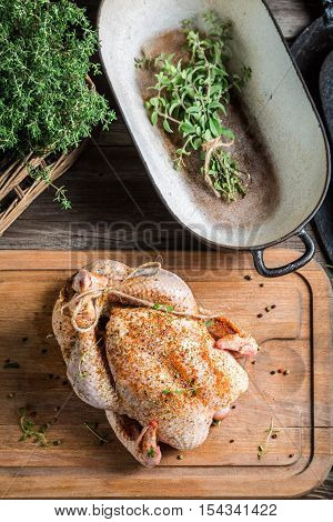 Preparing roast chicken with spices on wooden table