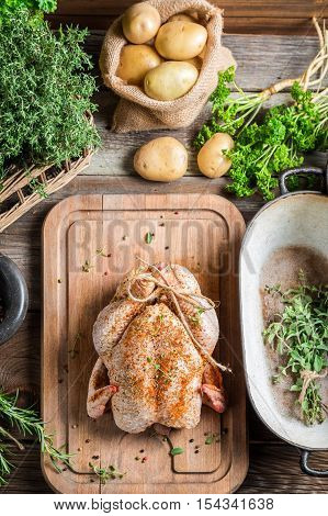 Preparing roast chicken with herbs and vegetables