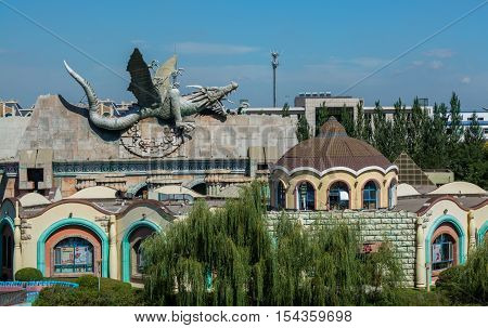 Roof of building decorated by the dragon body. Building in the asia theme park.