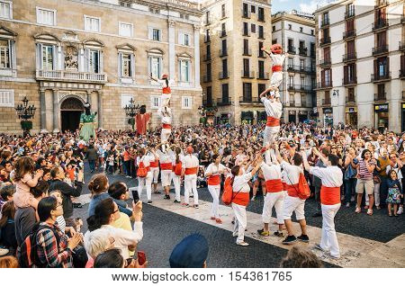 Barcelona Spain - May 29 2016: The Castellers de Barcelona of the Corpus Christi festival stand in front of the historical town hall with Giant puppets Gigantes and viewers.