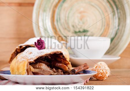 Piece of apple strudel and coffee cup on wood desk. Food background