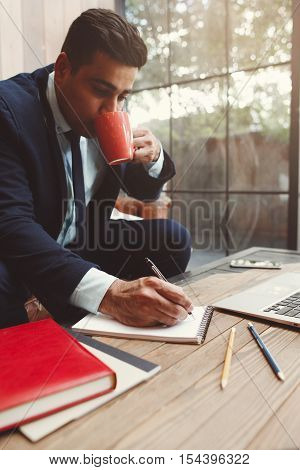 Office employee doing work at office. Businessman having coffee break while working. Hardworking, workaholism and overwork concept.
