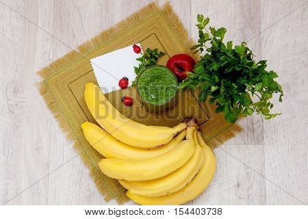 Vitamin smoothie in glass linen napkin on the kitchen table. A healthy diet of parsley and bananas. Cleansing Cocktail. Detox