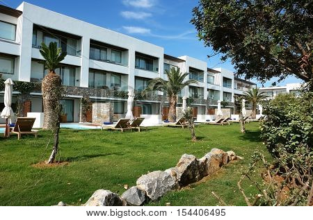 HERAKLION CRETE GREECE - MAY 13 2014: The blue sky modern building of villa with balcones and palms on the terrain of luxury class hotel on the Mediterranean coast of Crete May 13 2014 Greece.