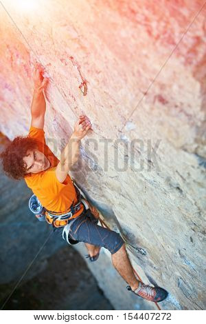 male rock climber. rock climber climbs on a rocky wall. focus on the hand