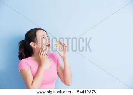 woman eating lemon feel very sour isolated on blue background