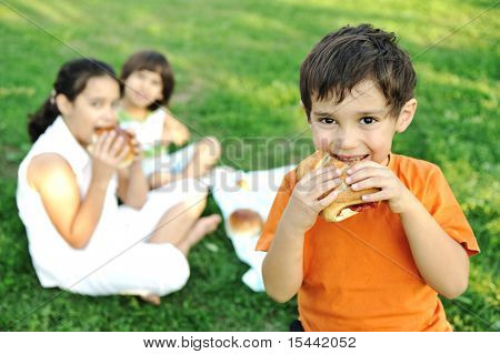 Kleine Gruppe von Kindern in der Natur Essen Snacks, Brötchen, Brot