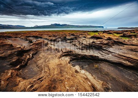 Sandy rocks with by magma formed by winds. Popular tourist attraction. Unusual and gorgeous scene. Location Sudurland, cape Dyrholaey, south coast of Iceland, Europe. Artistic picture. Beauty world.