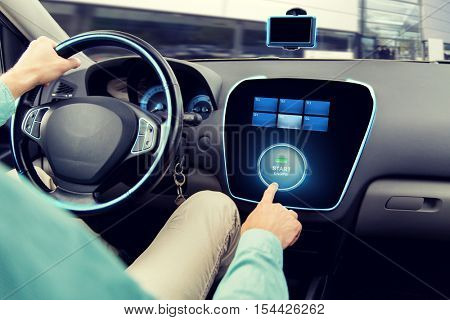 transport, road trip, car driving, technology and people concept - close up of man driving car and pushing start engine button on board computer
