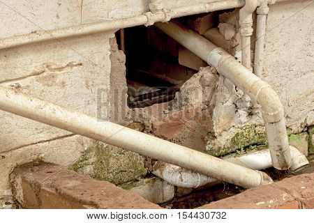 Close up of broken wall plumbing pipes and drain requiring mainenance and repair