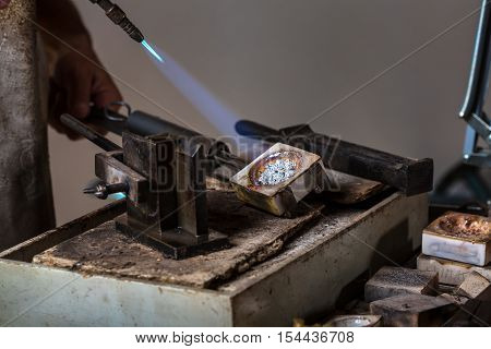 Melting Silver Grains to liquid state in crucible with blowtorch; Goldsmith Workshop