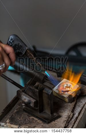 Melting Silver Grains to liquid state in crucible with blowtorch; Goldsmith Workshop; Close-up