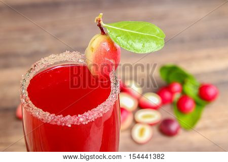 Carandas-plum  juice  in a glass on wooden background
