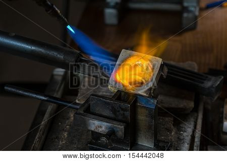 Metal Casting from Crucible to Metal Mold with blowtorch; Goldsmith Workshop; Close-up