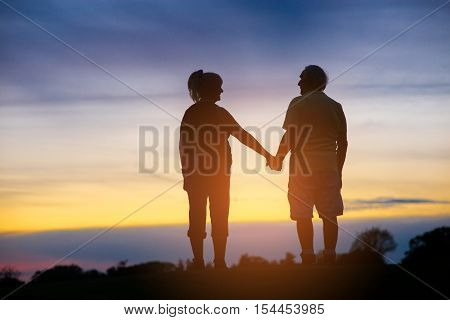 Two people holding hands. Back view of standing couple. Time is nothing. Be with me.