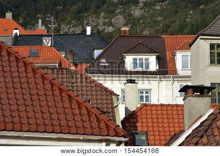 Red grey & brown tiled roofs on the mountain backgrownd in Bergen Norway