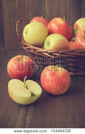 Apples in basket on wooden rustic background. Autumn and harvest concept selective focus toned vertical