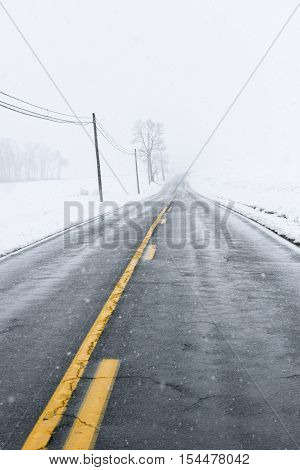 Empty Highway During Winter Snow Storm and Telephone Lines