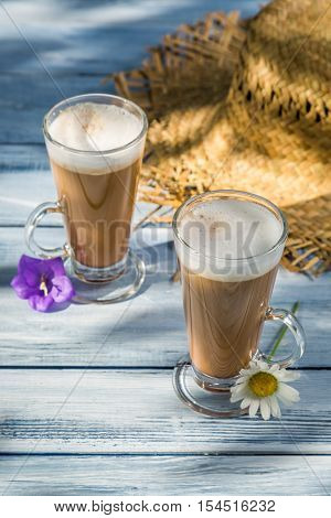 Coffee served in the sunny garden on old wooden table