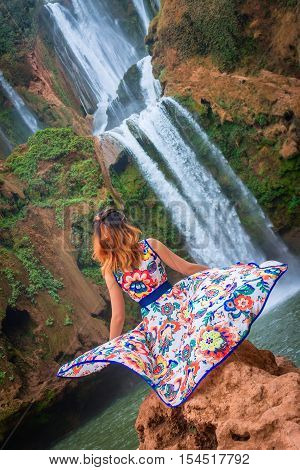Beautiful waterfall in Morocco. Back woman beautiful dress looking fall Ouzoud Grand Atlas. Exotic nature North Africa