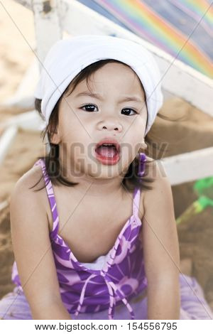 soft focused close up Asian little girl playing and her face dirty with sand