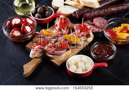 Spanish Tapas With Slices Jamon Serrano And Grilled Pepper. Also Olives, Salami, Pickled Onions, And