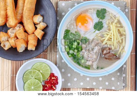Close up of rice porridge with mined pork and chicken lever served with side dish as Patongko (deep-fried dough stick) and spicy sour filling.