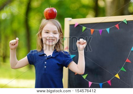 Very Excited Little Schoolgirl By A Chalkboard