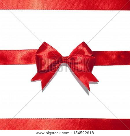 Red ribbon with bow on white. Studio shot