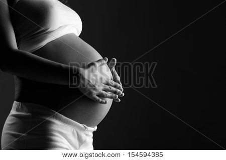 belly of pregnant woman monochrome on a dark background