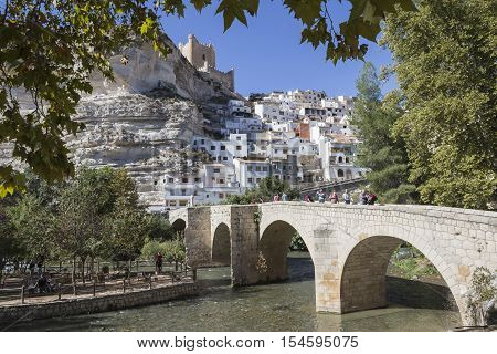Alcala del Jucar Spain - October 29 2016: Roman bridge located in the central part of the town to its passage by the river Jucar at the top of mountain limestone is situated castle of Almohad origin of the century XII take in Alcala of the Jucar Albacete