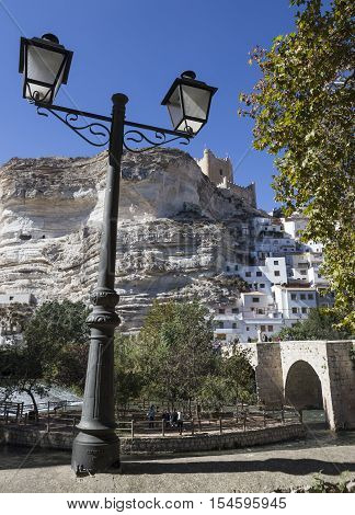 Alcala del Jucar Spain - October 29 2016: Roman bridge located in the central part of the town to its passage by the river Jucar at the top of mountain limestone is situated castle of Almohad origin of the century XII take in Alcala of the Jucar Albacete