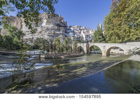 Alcala del Jucar Spain - October 29 2016: Roman bridge located in the central part of the town to its passage by the river Jucar at the top of mountain limestone is situated castle of Almohad origin of the century XII take in Alcala of the Jucar Albacete