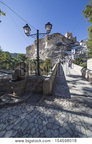 Alcala del Jucar Spain - October 29 2016: Roman bridge located in the central part of the town to its passage by the river Jucar at the top of mountain limestone is situated castle of Almohad origin of the century XII take in Alcala of the Jucar Albacete
