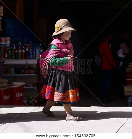 Peruvian girl dressed in colourful traditional handmade outfit. October 19 2012 - Ollantaytambo Peru