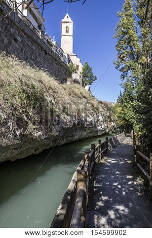Alcala del Jucar Spain - October 29 2016: Passage along the river Jucar left the church of San Andres styles late Gothic and Neoclassic take in Alcala of the Jucar Albacete province Spain