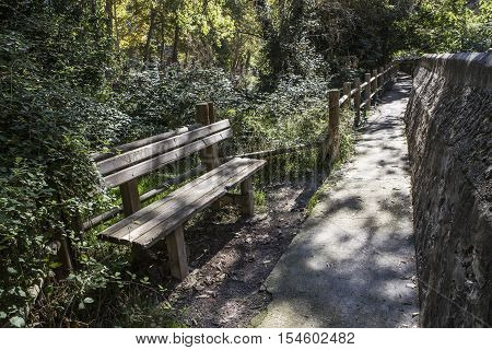 Alcala del Jucar Spain - October 29 2016: Passage along the river Jucar during autumn wooden bench take in Alcala of the Jucar Albacete province Spain
