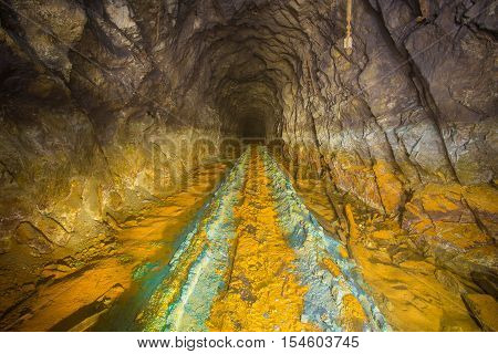 Old abandoned iron shaft mine tunnel with sulfur dirt