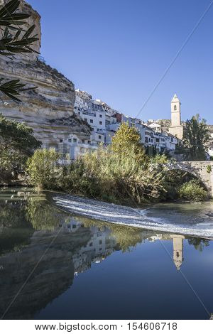 Alcala del Jucar Spain - October 29 2016: Roman bridge located in the central part of the town to its passage by the river Jucar Church of San Andres styles late Gothic and Neoclassic take in Alcala of the Jucar Albacete province Spain