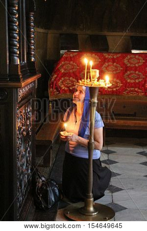 Woman brning candles in Church in Georgia