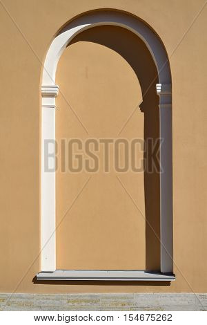 Arched false window in a light brown plastered wall