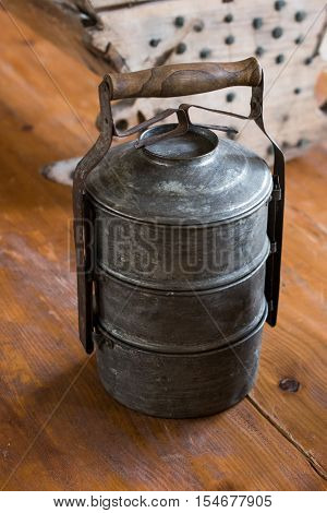 Old metal cookware placed on wood in a room