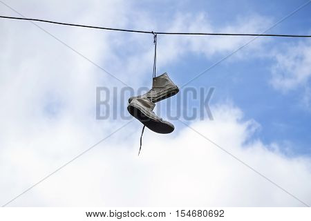 Sneakers hanging on wires on a background of blue sky. Sports Equipment.