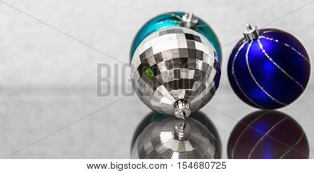 The composition of blue and silver Christmas balls. New Year's toys on a glass surface.